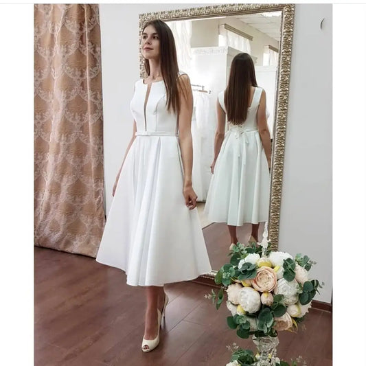 שמלת כלה קצרת סאטן ללא שרוולים באורך ברך שמלות כלה Charmin V-Neck A-Line לבן בהתאמה אישית תוצרת תחרה אלגנטית עבור